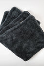 Folded dark gray microfiber car detailing towels on a white background